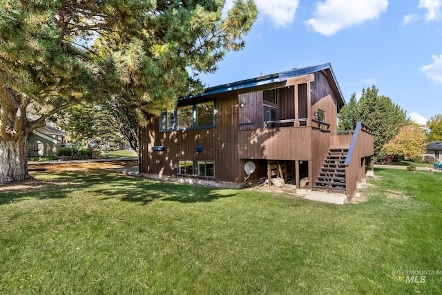 back of house with a wooden deck and a lawn