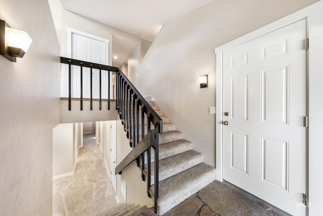 staircase featuring carpet flooring