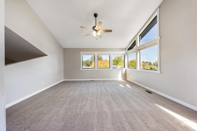 carpeted spare room featuring ceiling fan and lofted ceiling