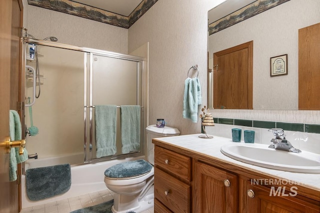 2555 E Quail Run Rd, Emmett, ID 83617 - bathroom with toilet, vanity, shower / bath combination with glass door, a textured wall, and decorative backsplash
