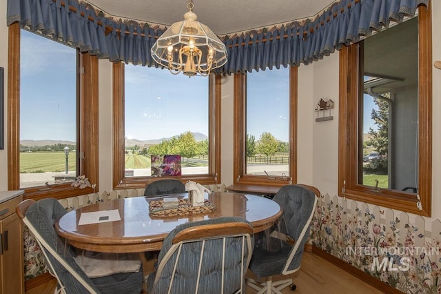 2555 E Quail Run Rd, Emmett, ID 83617 - dining space featuring a chandelier, wood finished floors, and baseboards