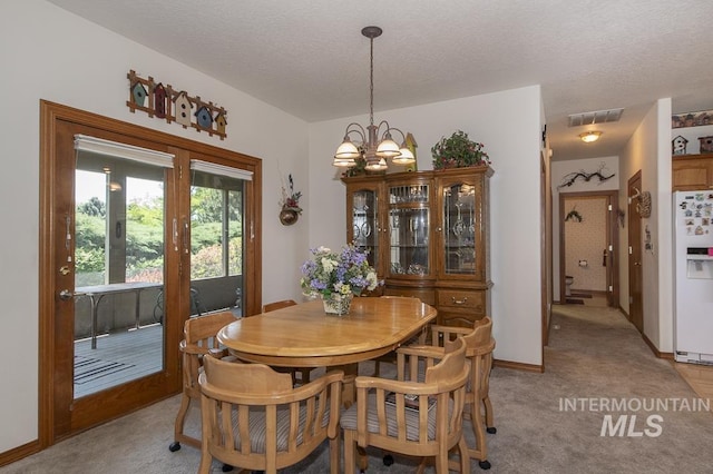 2555 E Quail Run Rd, Emmett, ID 83617 - dining space with light carpet, a textured ceiling, baseboards, and a chandelier