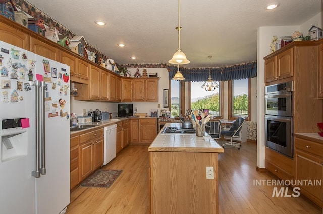 2555 E Quail Run Rd, Emmett, ID 83617 - kitchen with appliances with stainless steel finishes, a center island, light wood-style floors, recessed lighting, and decorative light fixtures