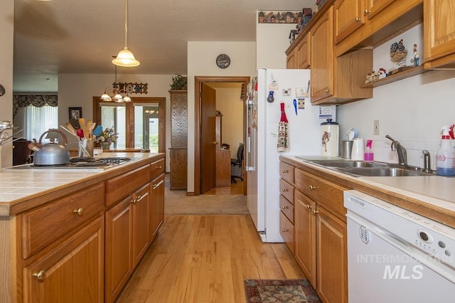 2555 E Quail Run Rd, Emmett, ID 83617 - kitchen featuring white appliances, a sink, light wood finished floors, brown cabinetry, and tile countertops