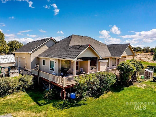 back of property featuring a yard and a shingled roof