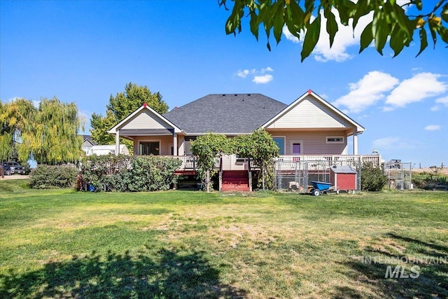 rear view of property featuring a lawn