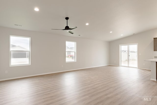 unfurnished living room featuring a healthy amount of sunlight, visible vents, and light wood finished floors