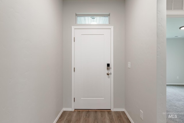 doorway to outside featuring light wood-style flooring and baseboards