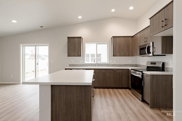 kitchen featuring light countertops, visible vents, appliances with stainless steel finishes, vaulted ceiling, and a sink