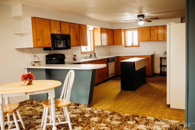 421 Hill St, Grangeville, ID 83530 - kitchen featuring black appliances, brown cabinets, a peninsula, ceiling fan, and light countertops