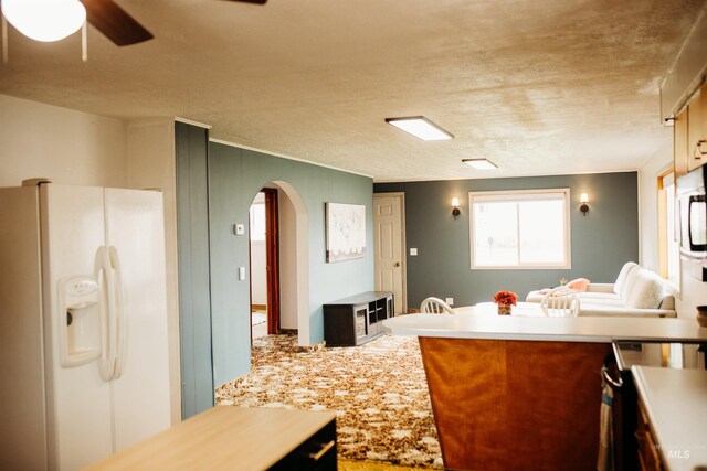 421 Hill St, Grangeville, ID 83530 - kitchen featuring white fridge with ice dispenser, arched walkways, ceiling fan, stainless steel electric range, and light countertops