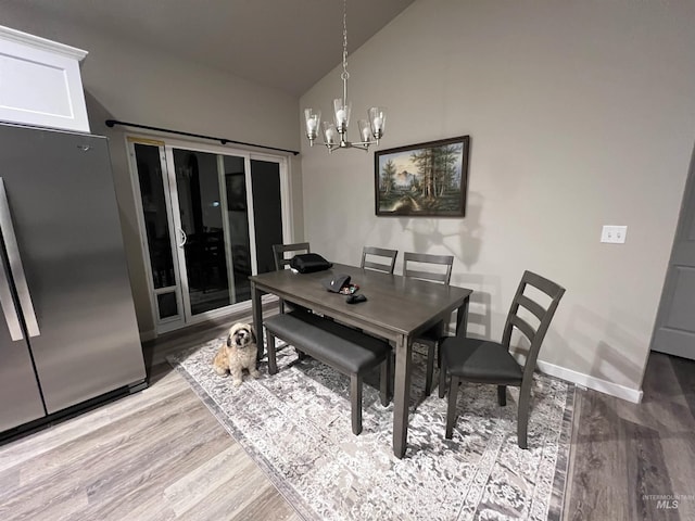 720 Shadowleaf Ave, Twin Falls, ID 83301 - dining space featuring lofted ceiling, a chandelier, wood finished floors, and baseboards