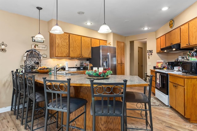 kitchen featuring light hardwood / wood-style floors, electric stove, stainless steel refrigerator with ice dispenser, and hanging light fixtures