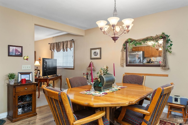 dining space featuring beam ceiling, light hardwood / wood-style floors, and an inviting chandelier