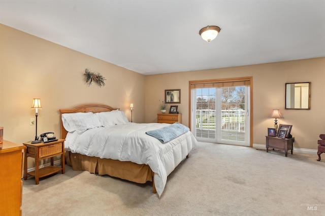 bedroom featuring access to exterior and light carpet