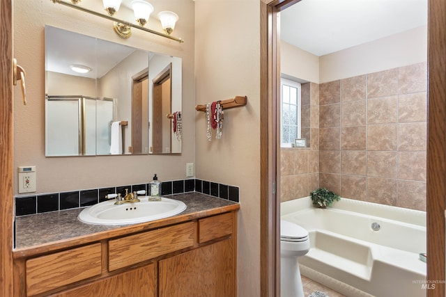 full bathroom featuring vanity, toilet, and separate shower and tub