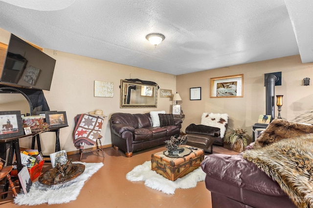 living room with a wood stove, concrete flooring, and a textured ceiling