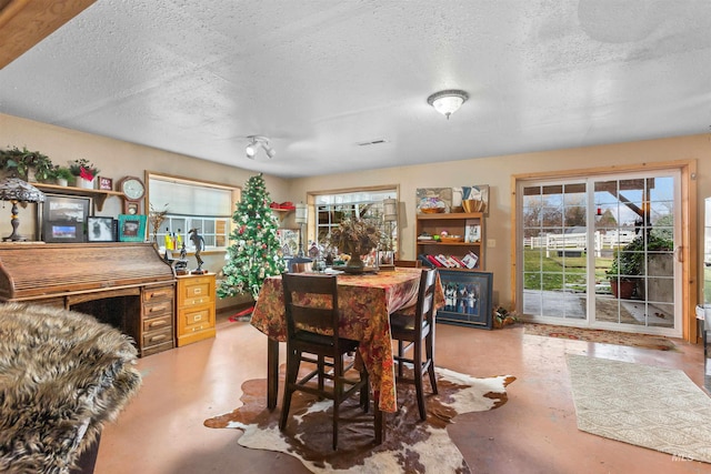 dining room with a textured ceiling and concrete floors