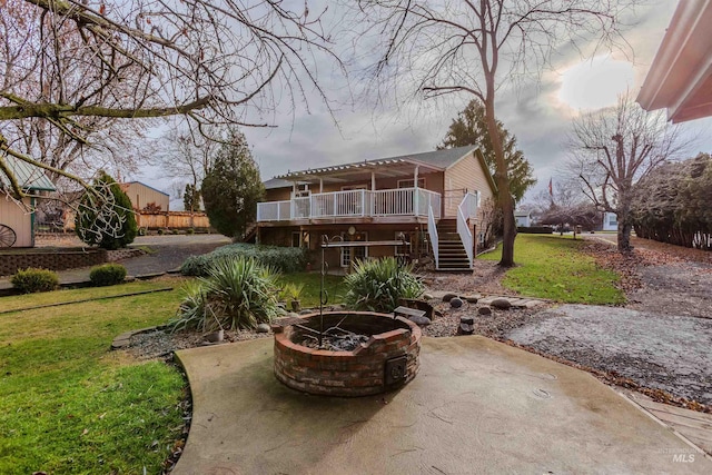 back of property featuring a lawn, a patio area, and an outdoor fire pit