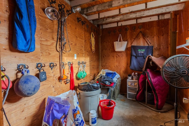 misc room featuring concrete flooring and wooden walls