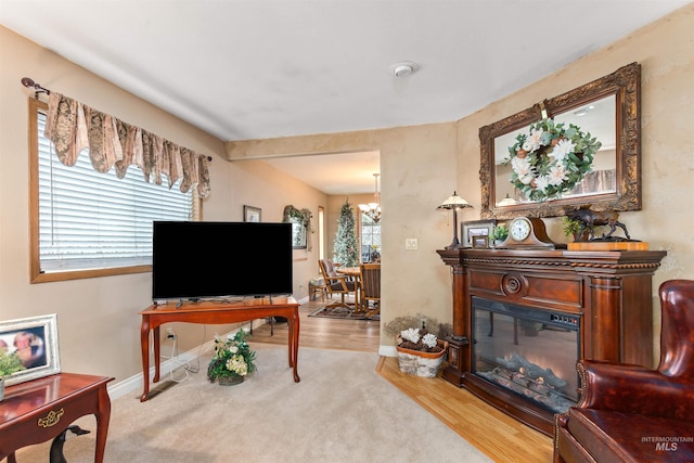 living area with light carpet and an inviting chandelier