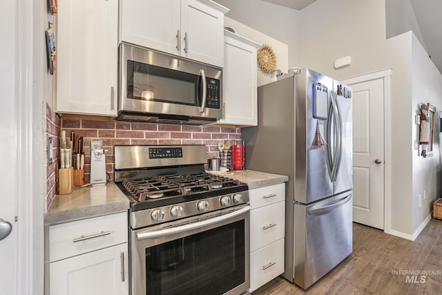 kitchen with white cabinetry, appliances with stainless steel finishes, and backsplash