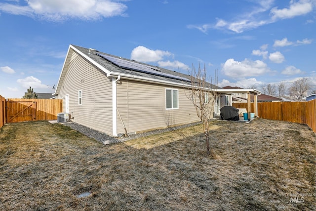 view of home's exterior featuring a yard, central AC unit, and solar panels