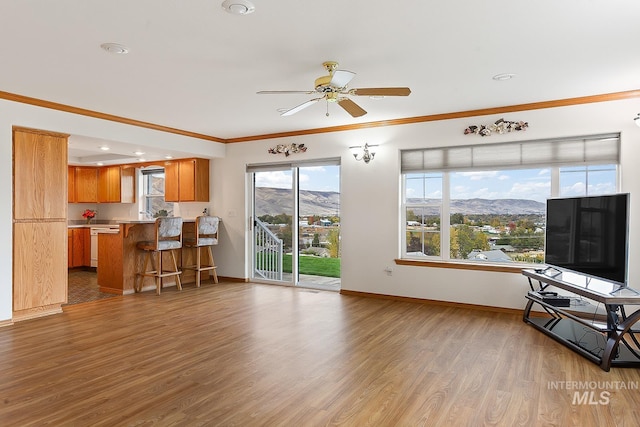 living room with crown molding, wood-type flooring, and ceiling fan