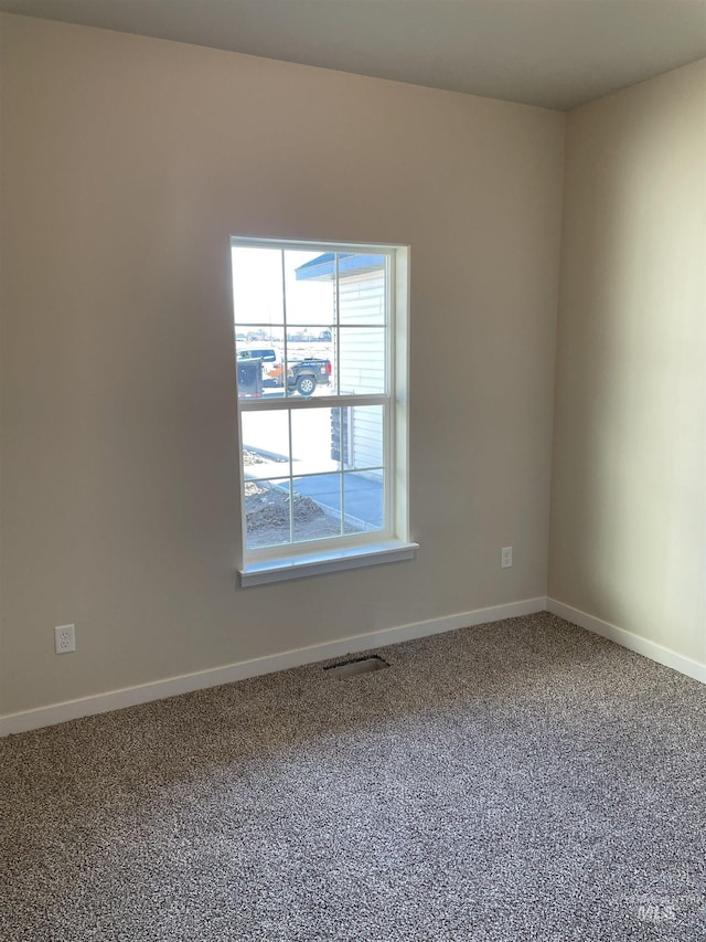 carpeted empty room with visible vents and baseboards