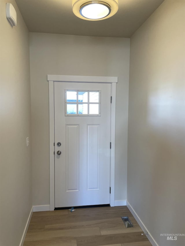 doorway to outside with visible vents, baseboards, and wood finished floors