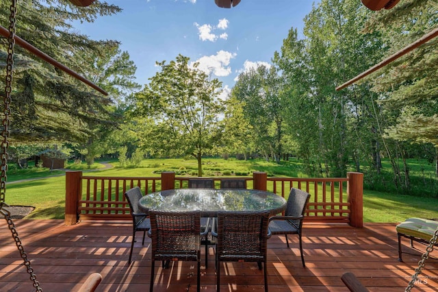 1301 Glen Aspen Dr, Bellevue, ID 83313 - deck with outdoor dining space, a lawn, and view of wooded area