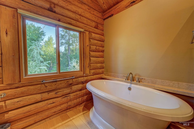 1301 Glen Aspen Dr, Bellevue, ID 83313 - bathroom featuring log walls, a soaking tub, wood finished floors, and wooden ceiling