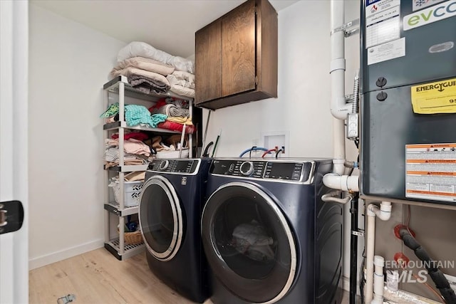 5009 Airport Rd, Nampa, ID 83687 - laundry area with cabinet space, washing machine and dryer, light wood-style floors, and baseboards