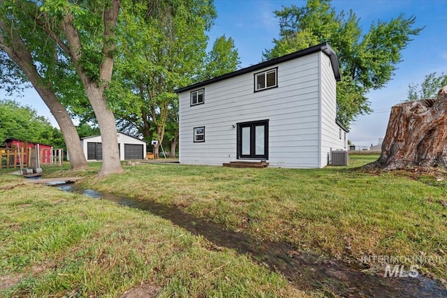 5009 Airport Rd, Nampa, ID 83687 - rear view of property featuring entry steps, a garage, central AC unit, a lawn, and french doors