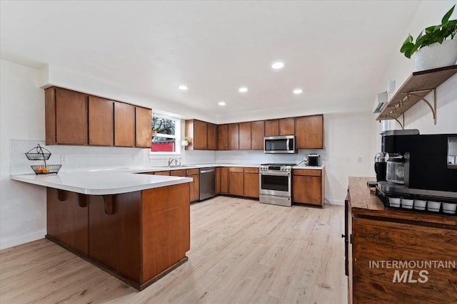 5009 Airport Rd, Nampa, ID 83687 - kitchen with stainless steel appliances, a peninsula, a sink, light wood-style floors, and recessed lighting