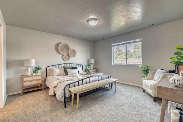 carpeted bedroom with a textured ceiling, baseboards, and visible vents