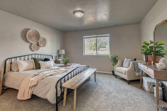 carpeted bedroom featuring baseboards, a textured ceiling, and visible vents