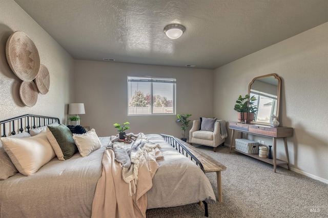 carpeted bedroom featuring baseboards, a textured ceiling, and visible vents