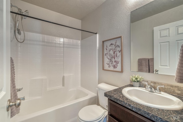 bathroom with vanity, a textured wall, bathtub / shower combination, and toilet
