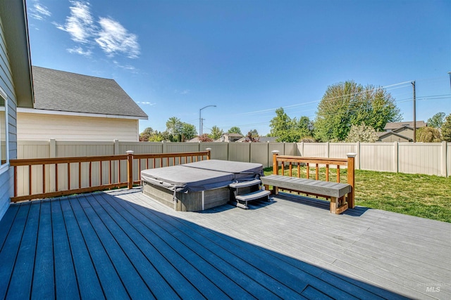 deck with a covered hot tub, a yard, and a fenced backyard