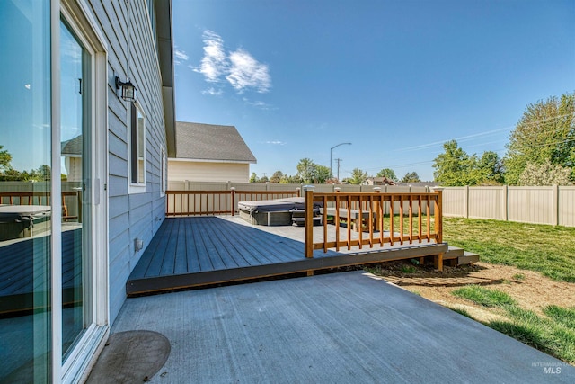 wooden deck with a covered hot tub, a lawn, a fenced backyard, and a patio area