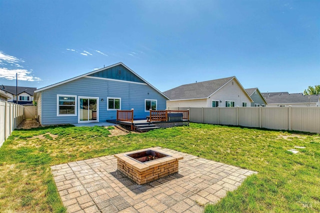 rear view of property featuring a fenced backyard, a deck, a fire pit, and a patio area