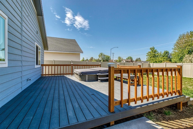 deck featuring a fenced backyard and a covered hot tub