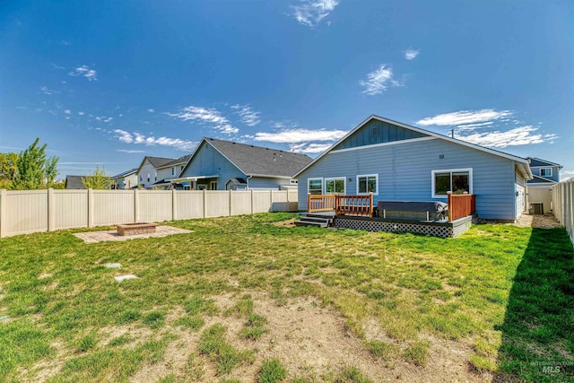 back of property featuring a fenced backyard, board and batten siding, a yard, and a deck