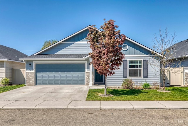 view of front of property with board and batten siding, an attached garage, driveway, and a front yard