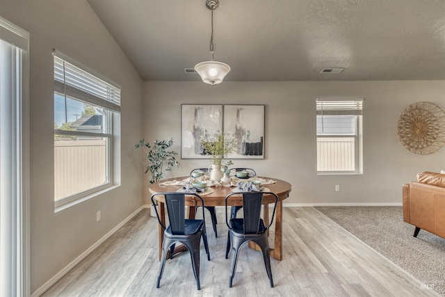 dining space featuring light wood-style floors, baseboards, and a healthy amount of sunlight