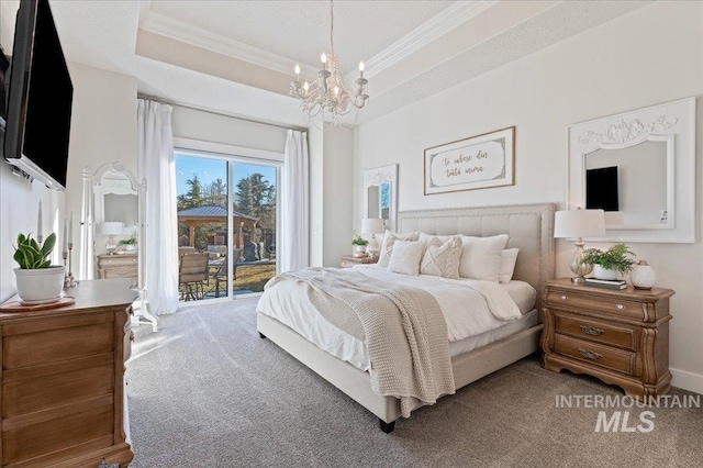 bedroom featuring access to outside, a tray ceiling, and ornamental molding