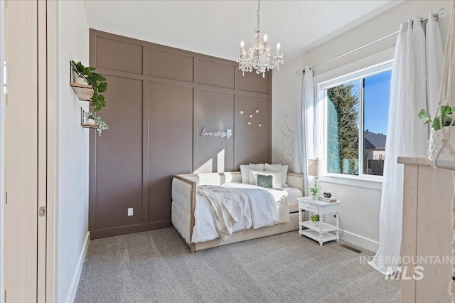 bedroom with carpet flooring, visible vents, baseboards, and an inviting chandelier