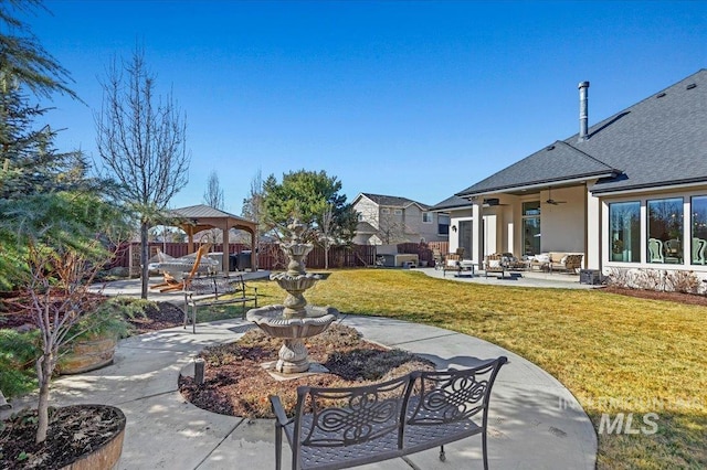 view of community with a lawn, a gazebo, a patio area, fence, and an outdoor living space