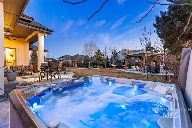 view of swimming pool featuring outdoor dining space, a patio area, a hot tub, and a gazebo